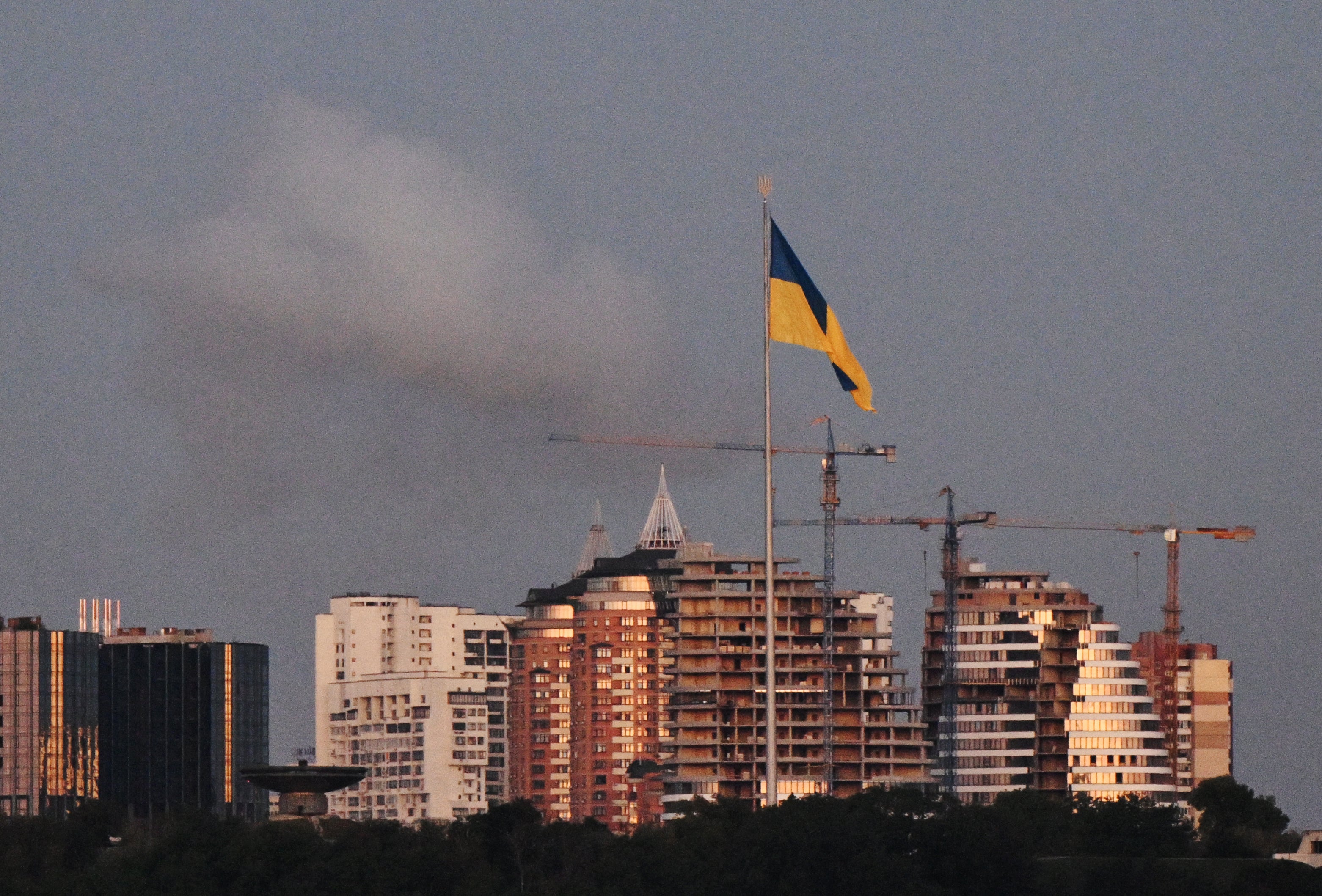 Dim se uzdiže iza divovske ukrajinske zastave tijekom velikog ruskog drona i raketnog napada na Kijev