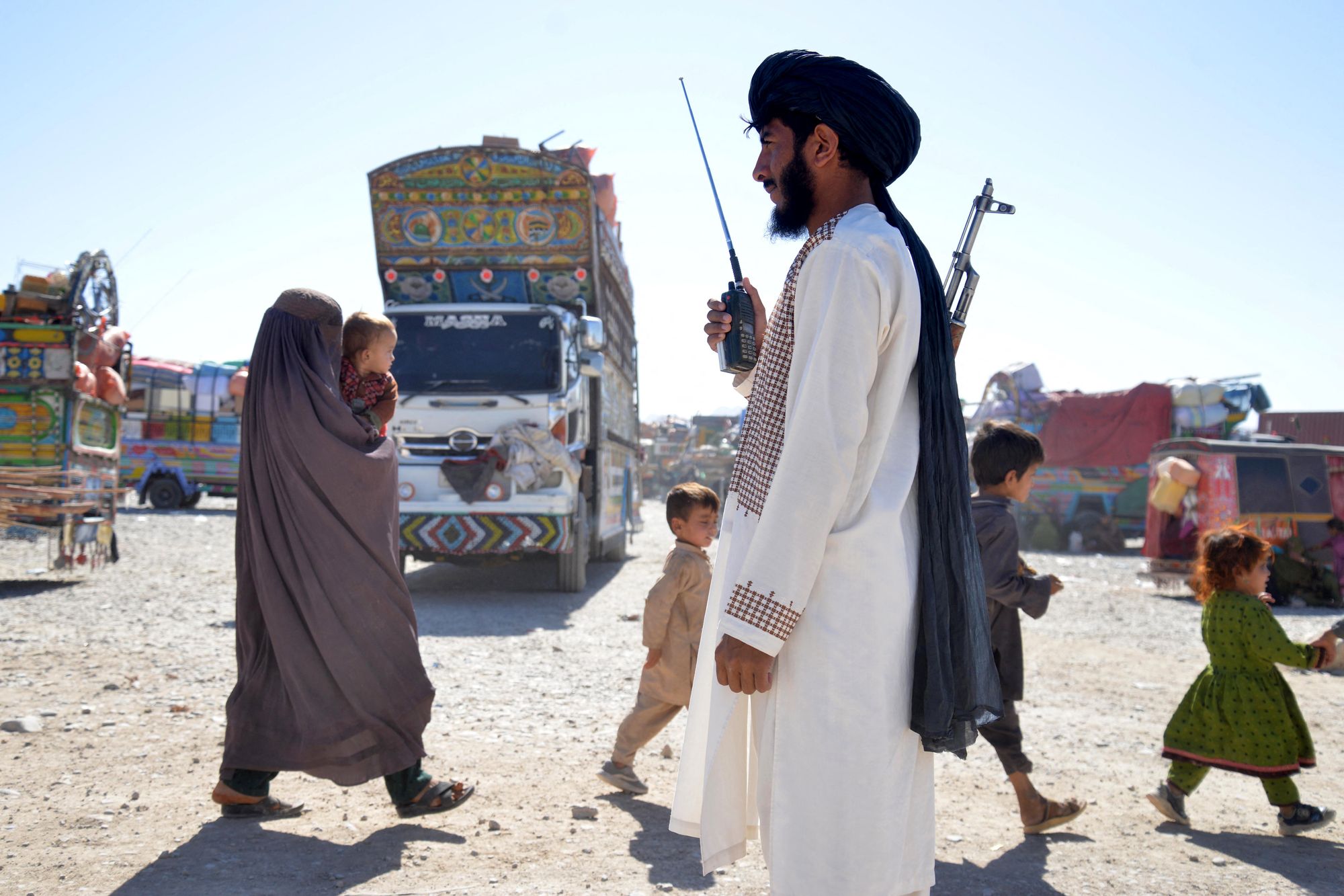 Sigurnosno osoblje talibana stoji dok Afganistanci deportirani iz Pakistana stižu u registracijski centar u Takhta pul u provinciji Kandahar, 9. listopada 2025. godine.