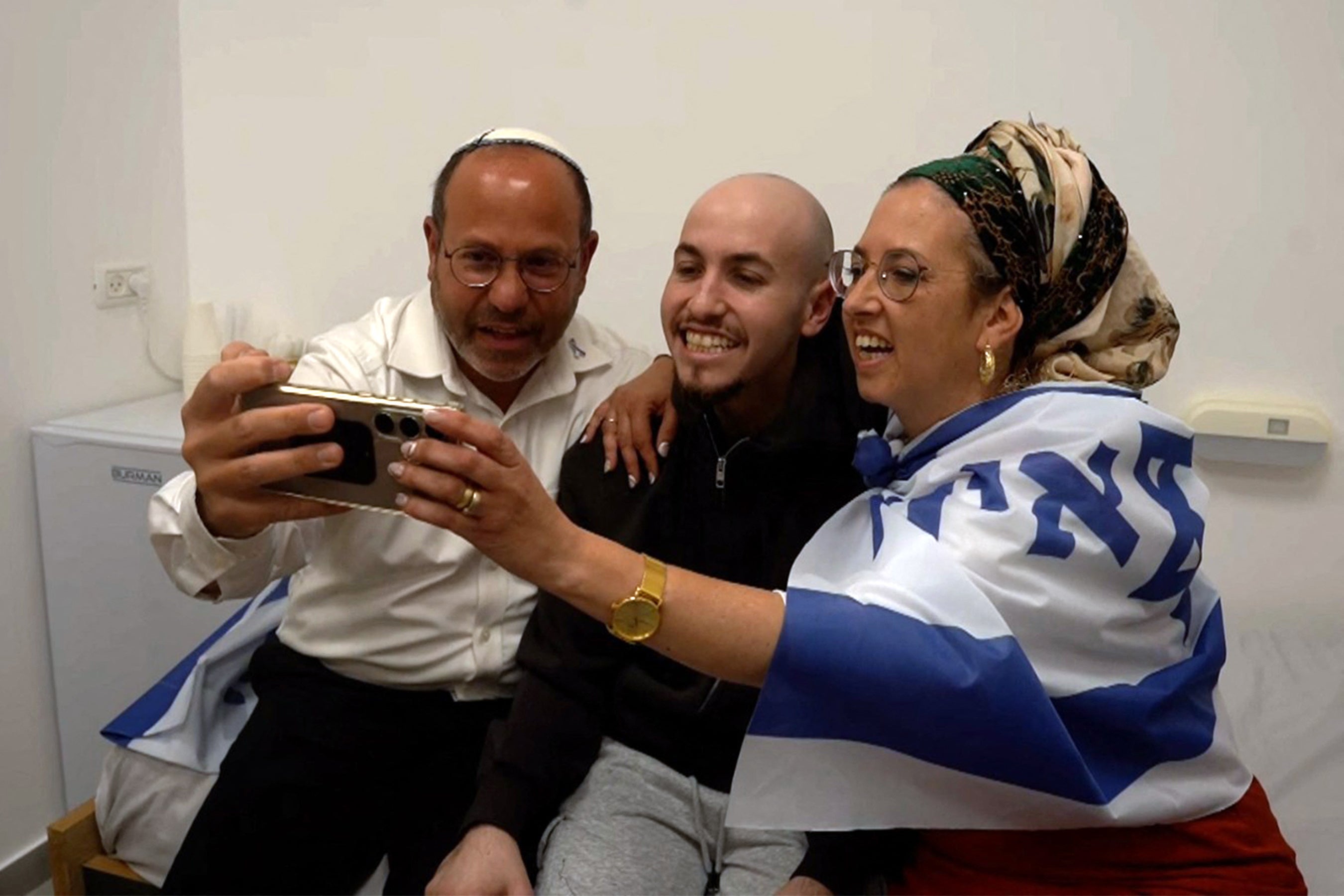 Ovu sliku priručnika koju je objavila izraelska vojska prikazala je izraelski talac Eitan Mor (C), jedan od bivših zarobljenika u Gazi od 2023. godine, 7. listopada, napadi palestinskih militanata, pozirajući za sliku sa svojom obitelji nakon što su se ponovno ujedinili