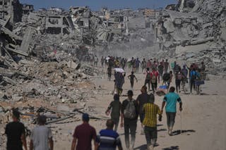 Raseljeni Palestinci prolaze pored uništenih zgrada dok se vraćaju svojim domovima u susjedstvu Zeitoun u gradu Gaza