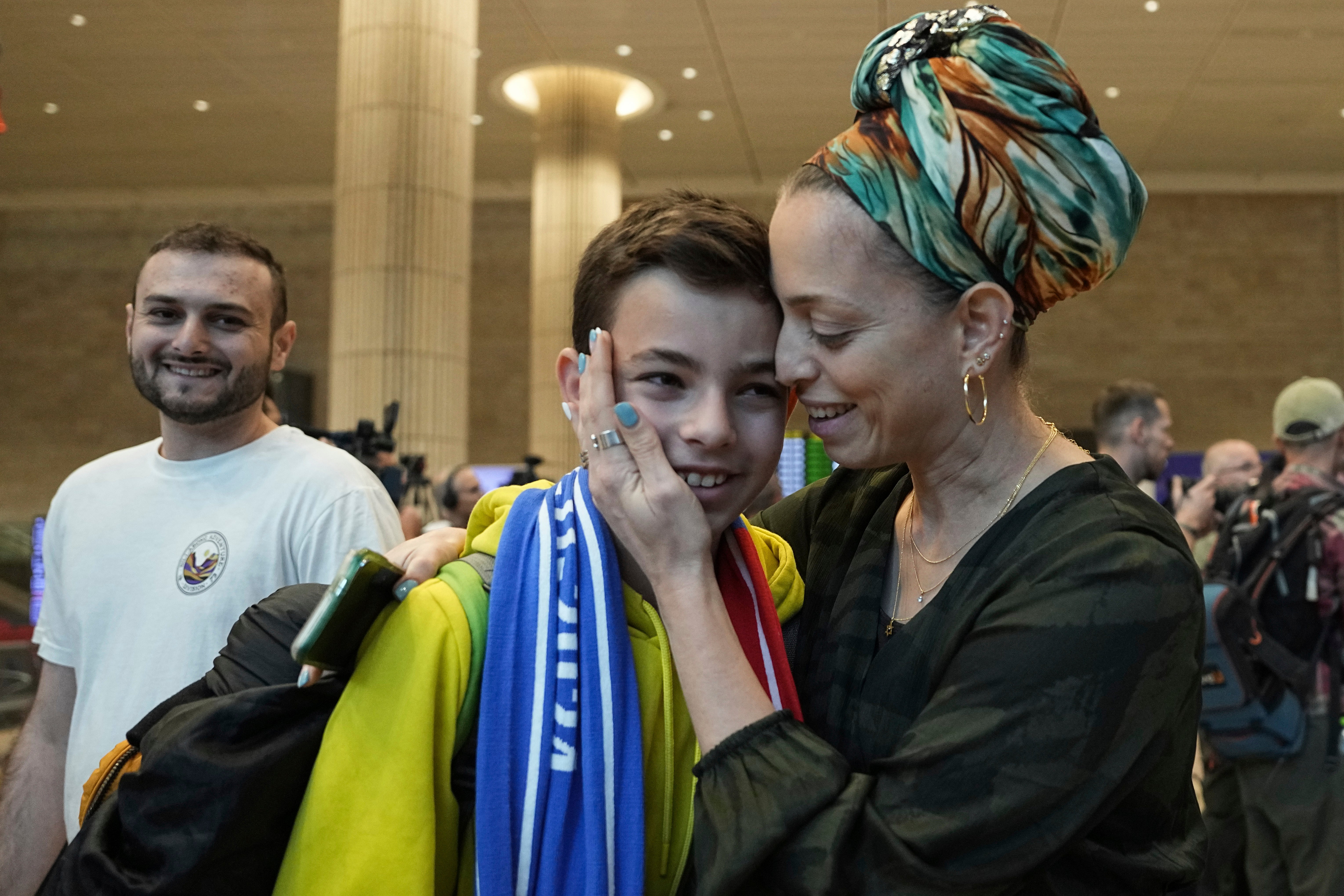 Žena grli svog sina, koji je navijač Maccabi Tel Aviva, dok stiže u izraelsku međunarodnu zračnu luku Ben-Gurion