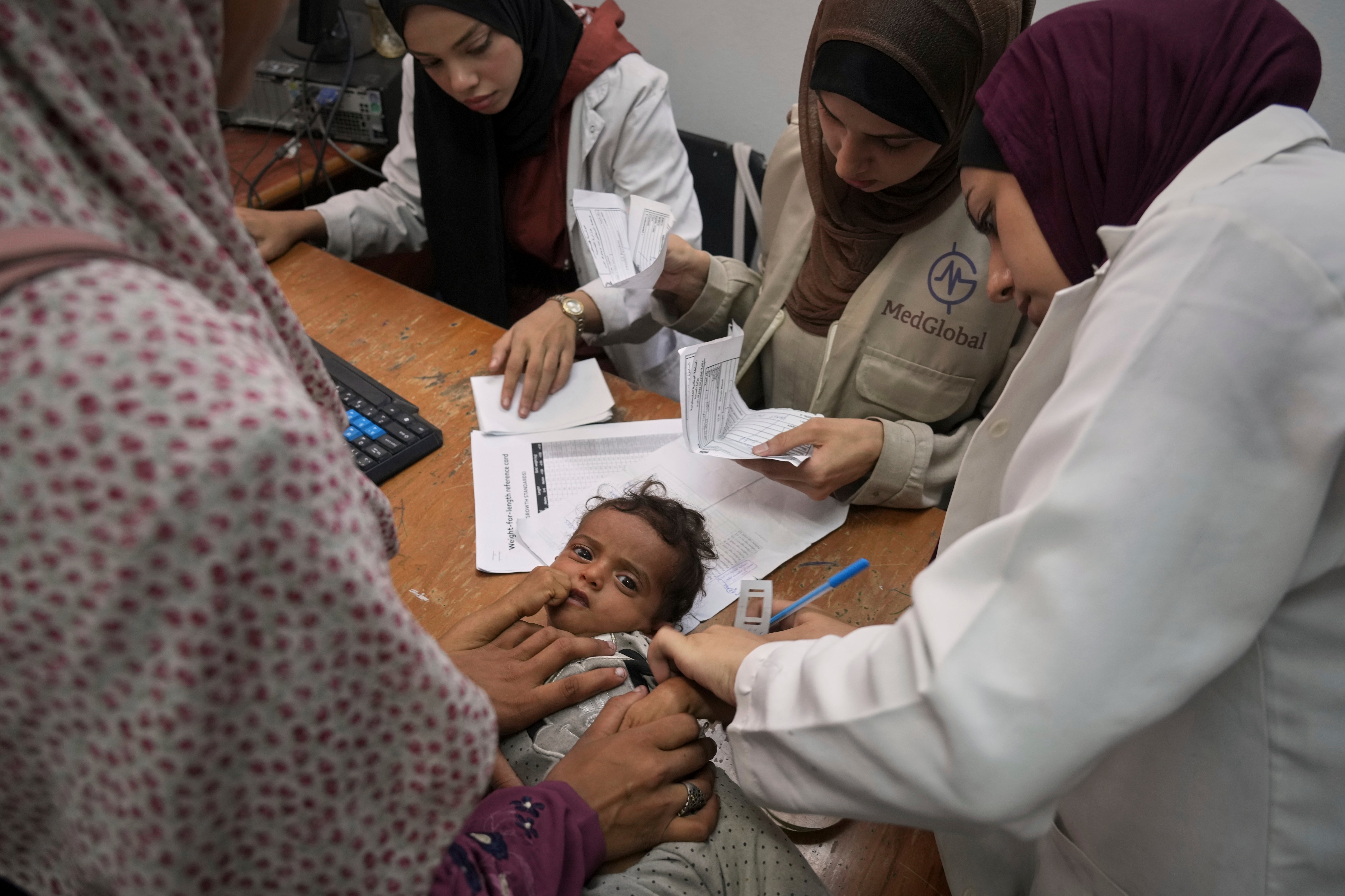 Liječnik u gradu Gazi mjeri djetetovu ruku kako bi provjerio ima li znakova pothranjenosti