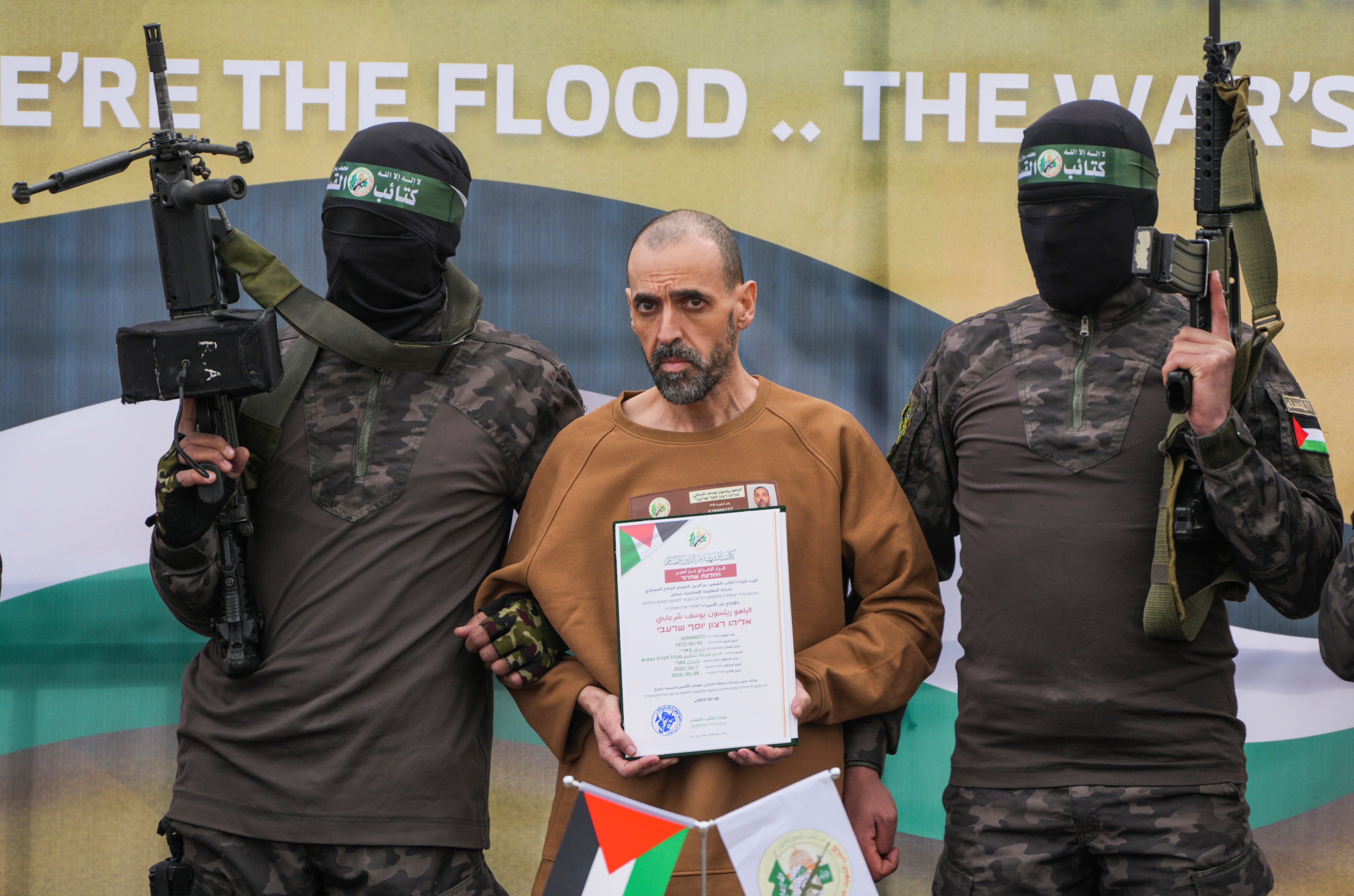 Izraelski zarobljenik, Eli Sharabi, koju je Hamas u Gazi držao taoca od 7. listopada 2023., stoji na pozornici koju su u pratnji Hamasovih borca prije predaje Crvenom križu u Deir Al-Balah, Strip u središnjoj Gazi, u subotu 8. veljače 8. veljače 8. veljače 8. veljače 8. veljače 8. veljače.