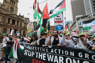 Demonstranti drže zastave i plakate dok se kreću u ulici George tijekom skupa za Gazu