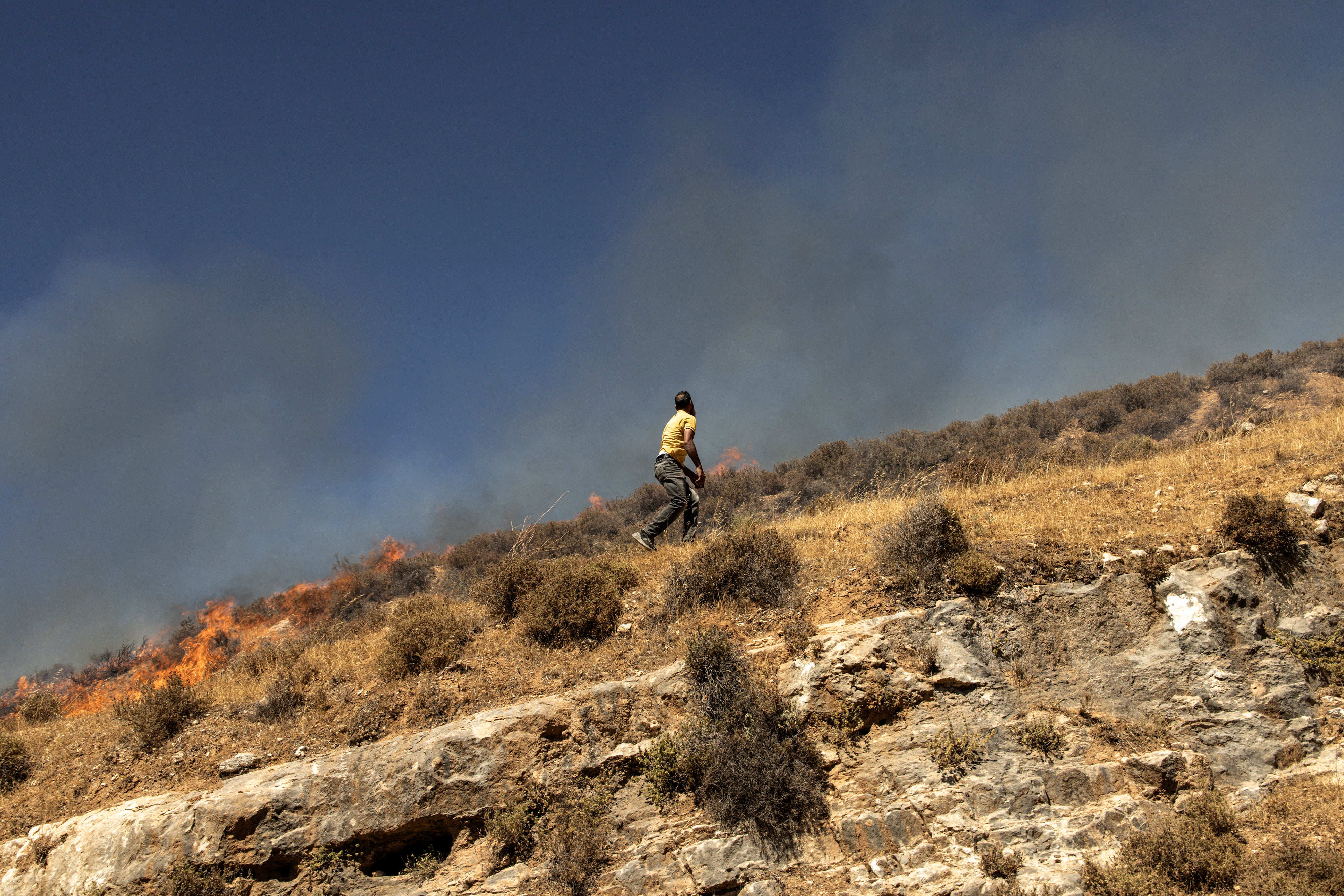 A Palestinian man runs across a hill as he tries to chase off Israeli settlers in the village of Sinjil - which is near where Sayf was killed - in the occupied West Bank on July 4, 2025.