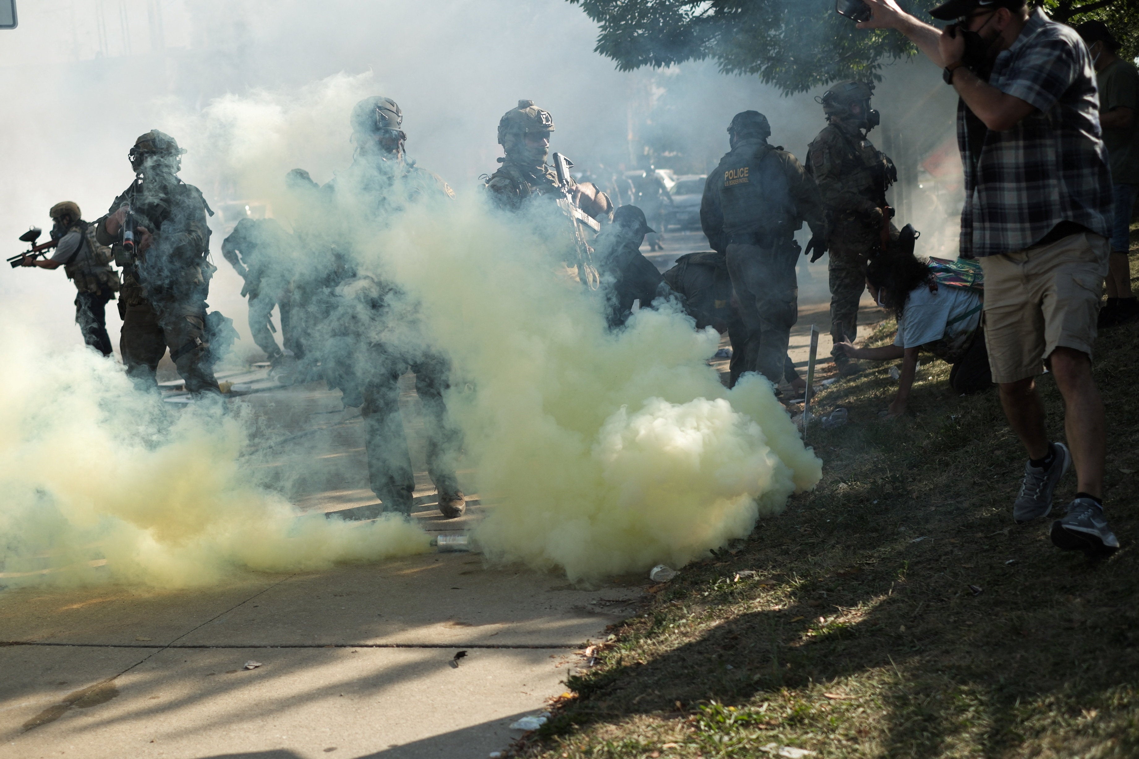 Službenici za provedbu zakona djeluju usred suzavog plina tijekom odstupanja s američkim imigracijom i carinskim provođenjem (ICE) i saveznim časnicima u susjedstvu Little Village u Chicagu, Illinois, 4. listopada