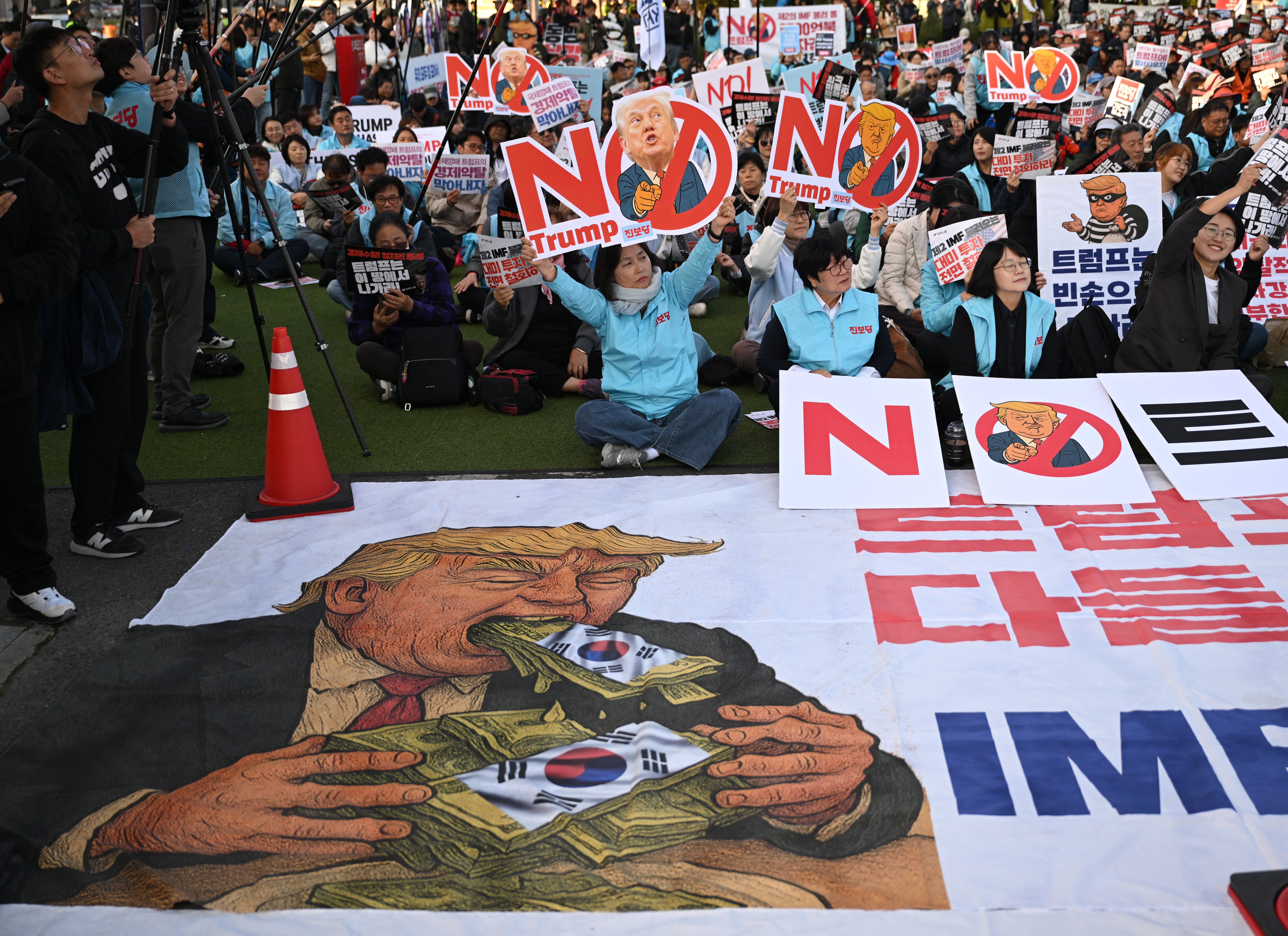 Prosvjednici su viđeni kako mašu transparentima s podrugljivim karikaturama američkog predsjednika