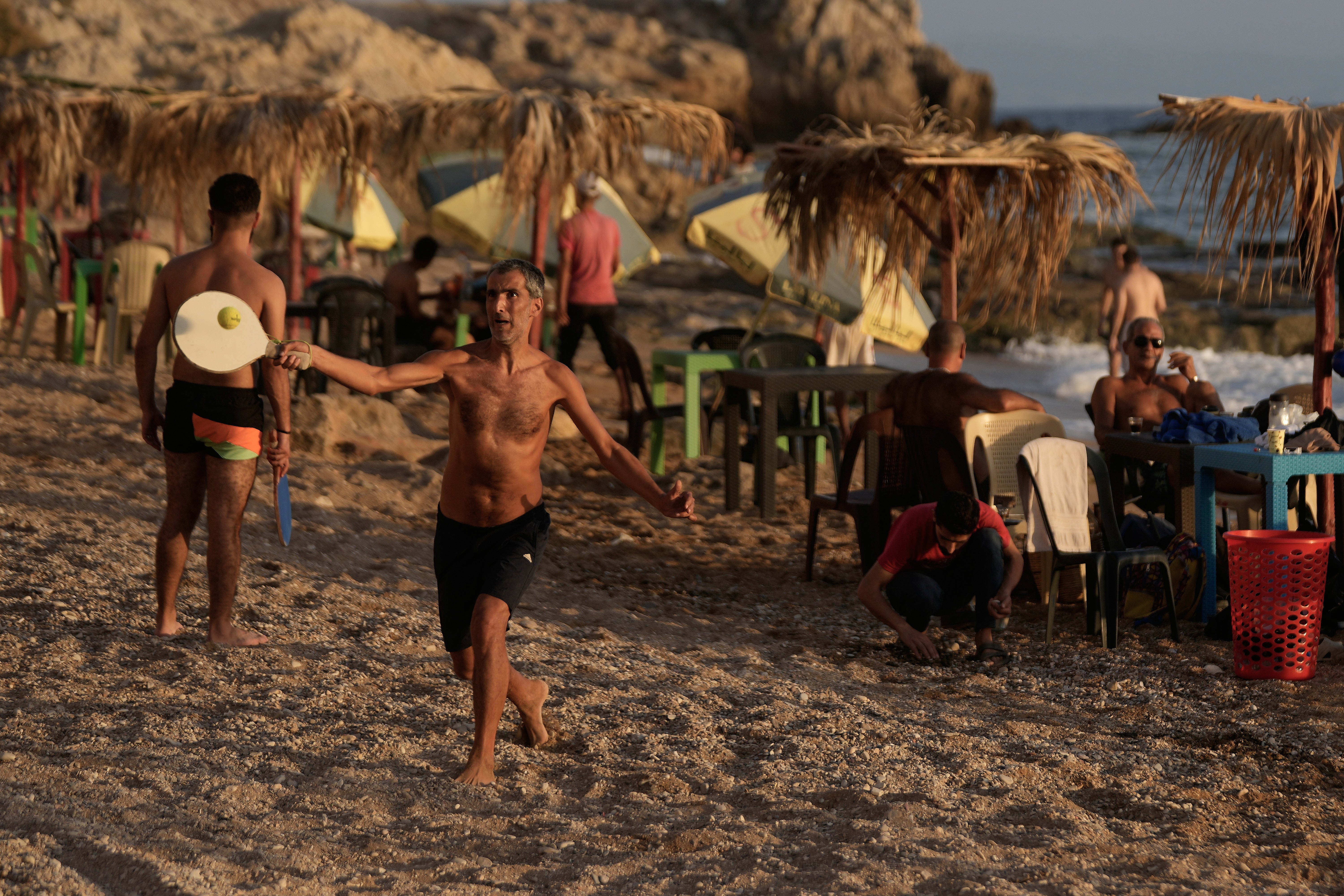 Ljudi igraju reketnu loptu na javnoj plaži na Sredozemnom moru, u obalnom gradu Latakia u Siriji