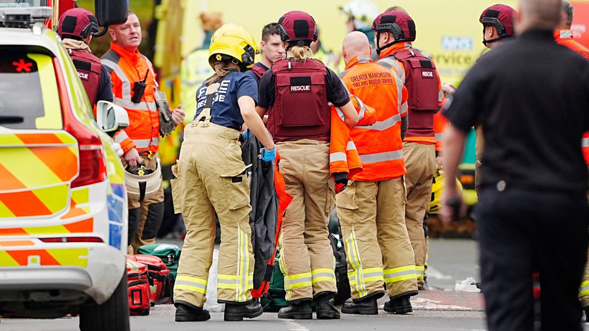 Vatrogasci i medicinski radnici reagiraju izvan hebrejske kongregacije Heaton Park u Manchesteru u Engleskoj, u četvrtak, 2. listopada 2025., nakon što je automobil odvezen u pješake, a muškarac je izboden. Policija je priopćila kako su četiri osobe ozlijeđene, a osumnjičenih su upucali policajci.