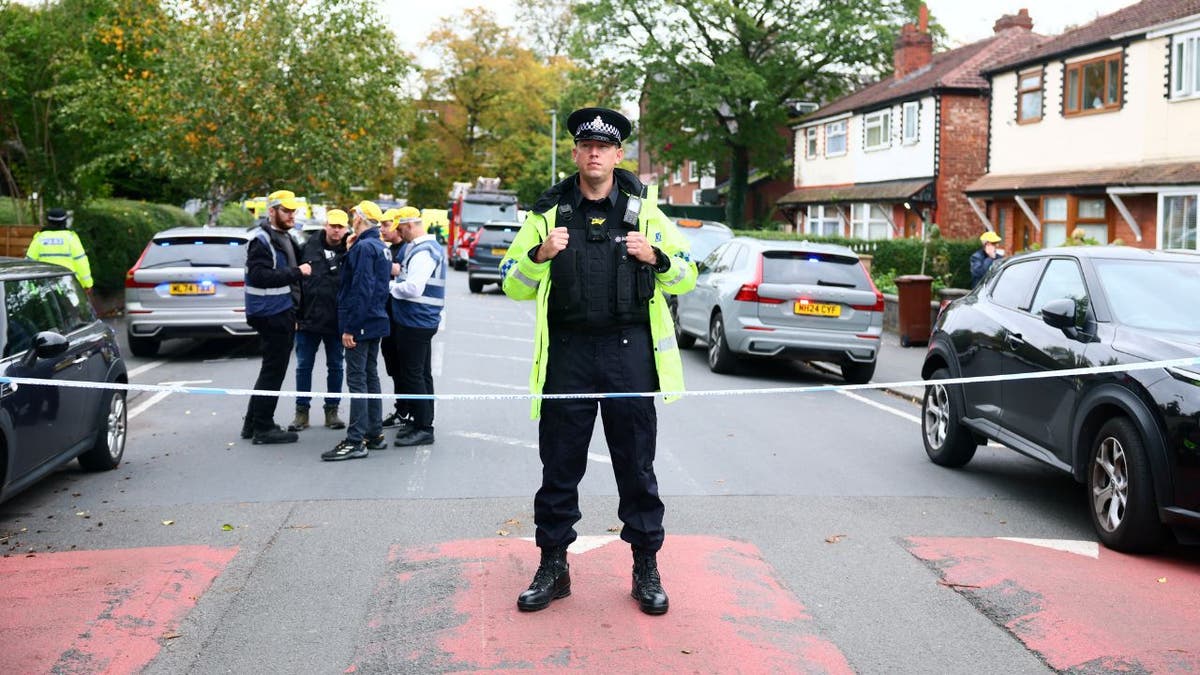 Policajac u jakni visoke vidljivosti stoji iza Cordona u blizini kuća nakon napada na Manchester sinagogu.