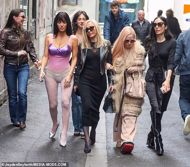 Njezina majka nosila je crnu midi haljinu Prade i odgovarajuću kožnu jaknu, dok je nosila crnu torbicu Hermès Kelly