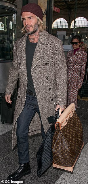 Godine 2018. činilo se da Sir David odražava kraljevu ljubav prema klasičnom tvidu u ovom teškom kaputu koji je nosio dok se ukrcavao na pariški Eurostar sa suprugom Victorijom