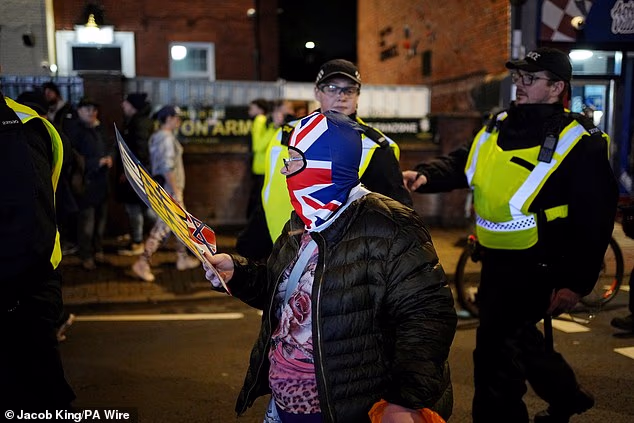 A pro-Israel fan is led by police along the streets of Birmingham before the Europa League fixture