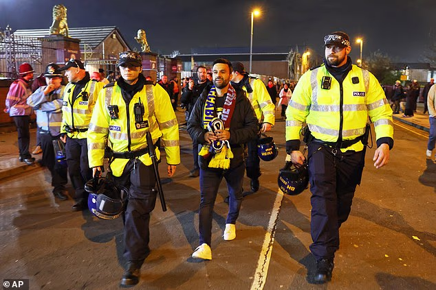 A solo Maccabi Tel Aviv fan is escorted by police along the roads by Villa Park