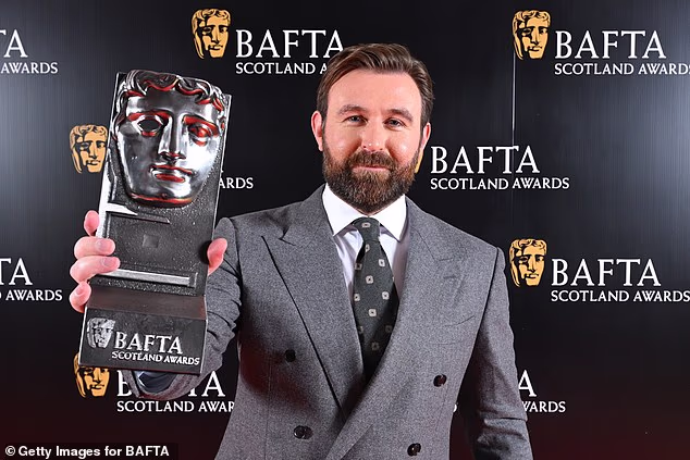 James McArdle se cerio od uha do uha dok je pozirao sa svojom nagradom za filmskog/televizijskog glumca