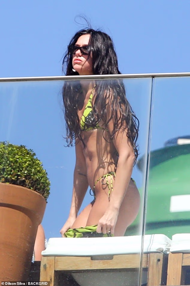 Uparila je crno-žuti dvodijelni kombinezon s odgovarajućom pokrivajućom suknjom dok su je vidjeli kako se sprema napustiti ležaljke