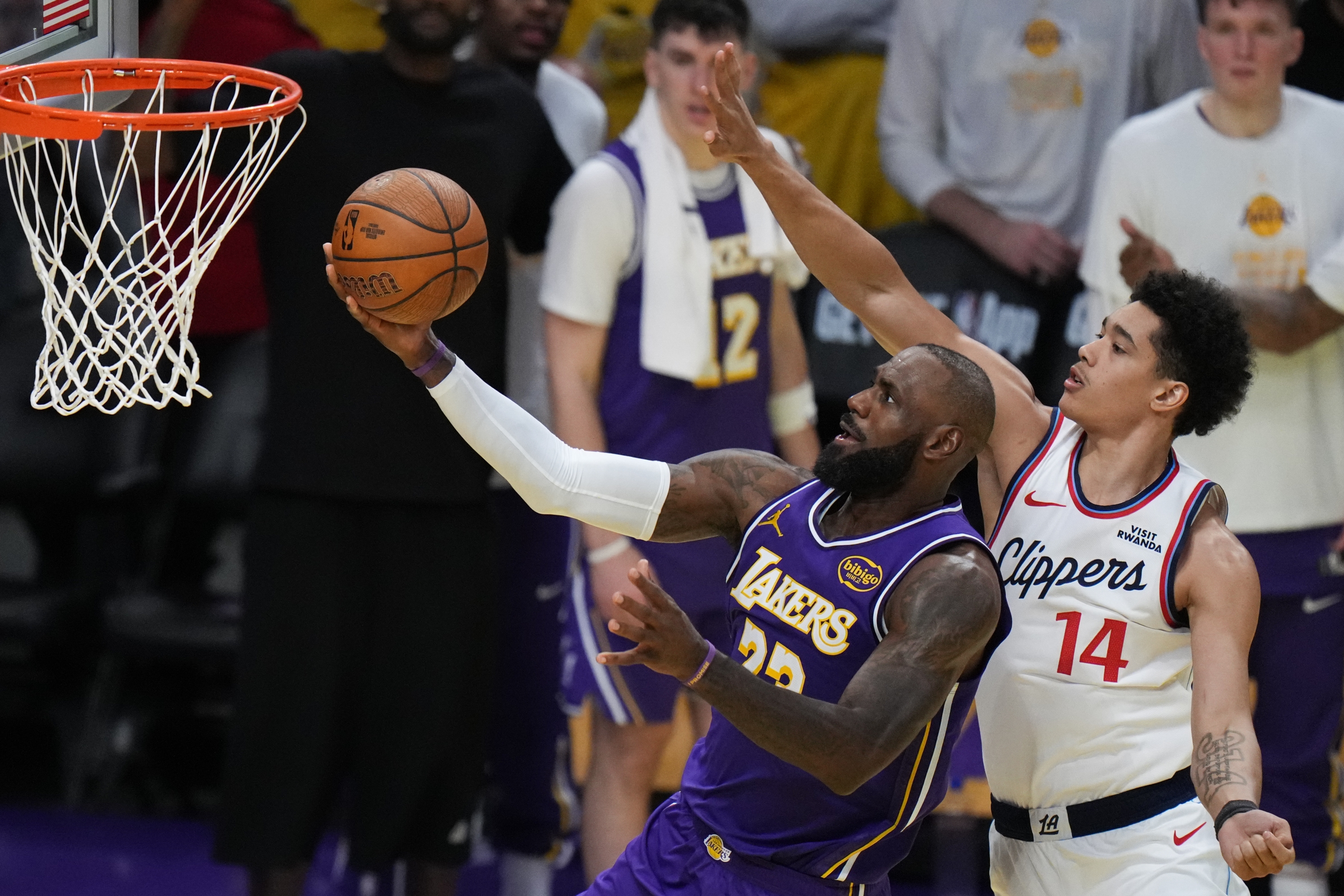 Napadač Los Angeles Lakersa LeBron James (23) puca protiv centra Los Angeles Clippersa Yanica Konana Niederhausera (14) tijekom drugog poluvremena košarkaške utakmice NBA kupa u utorak, 25. studenog 2025., u Los Angelesu. (AP Photo/Jae C. Hong)
