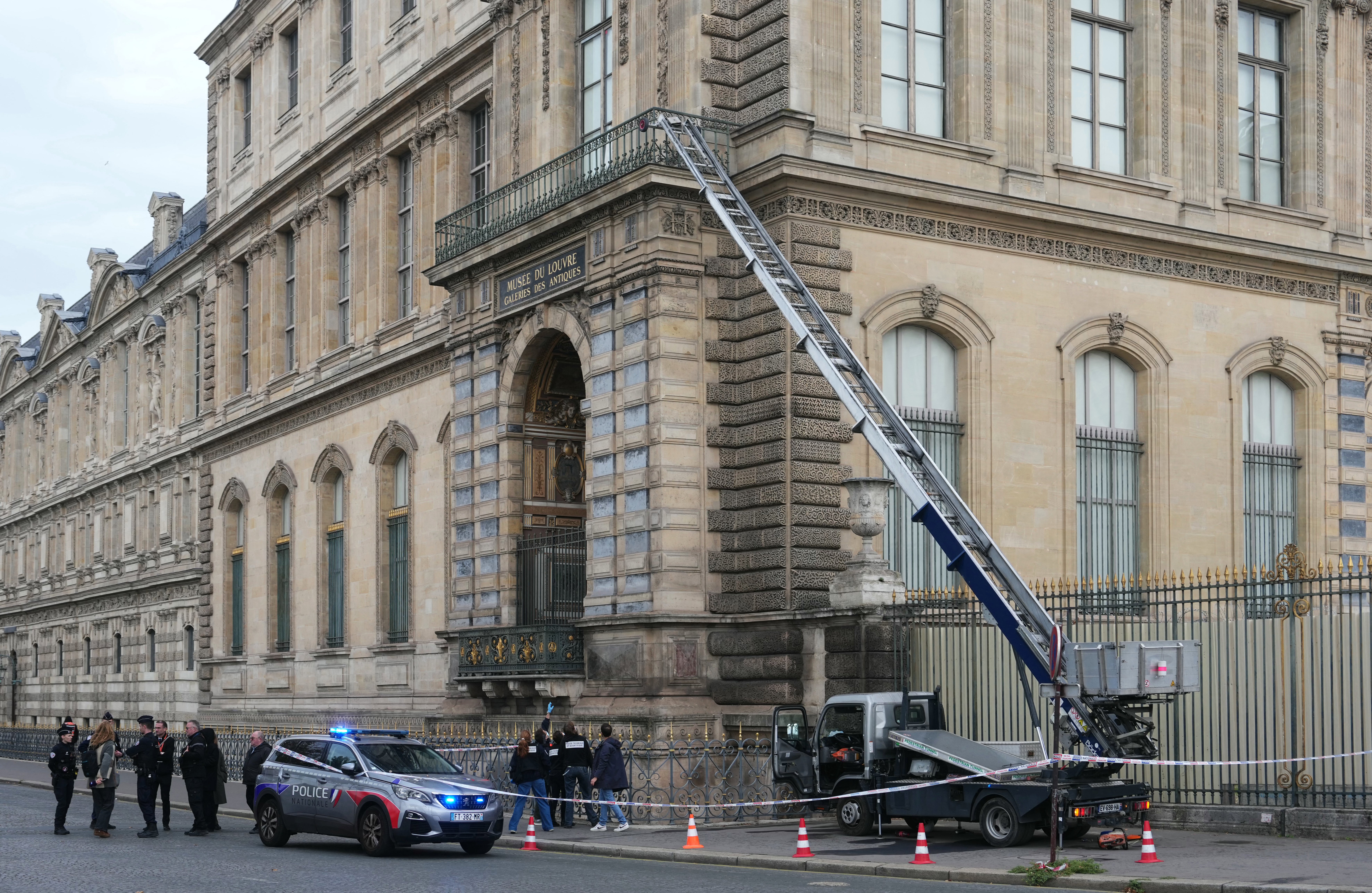 Francuski policajci stoje pored dizala za namještaj kojim su pljačkaši ušli u muzej Louvre, na Quai Francois Mitterrand, u Parizu 19. listopada 2025.