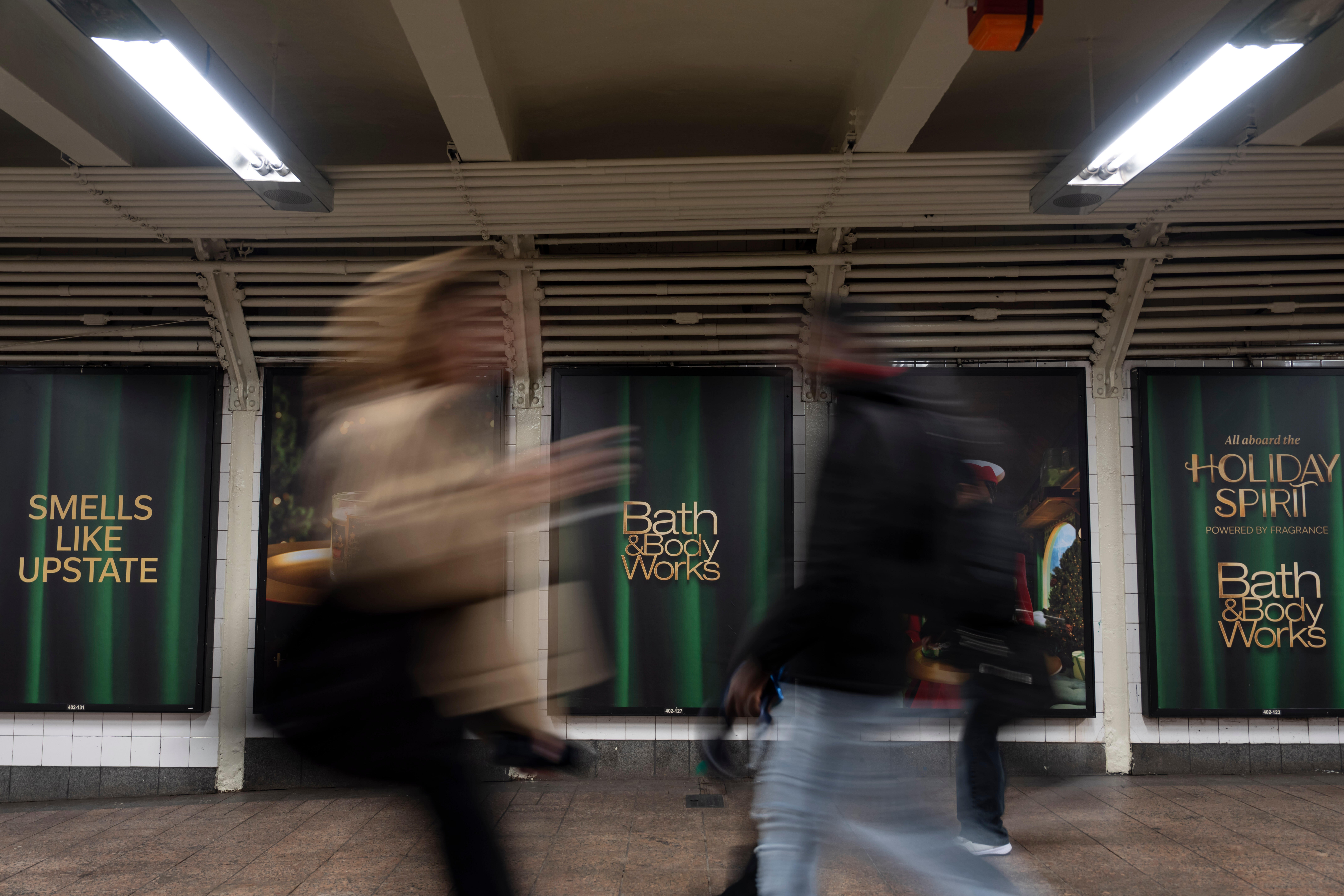 Ljudi prolaze pored plakata koji promoviraju kampanju tvrtke Bath & Body Works na terminalu Grand Central, u srijedu, 19. studenog 2025., u New Yorku. (AP Photo/Yuki Iwamura)