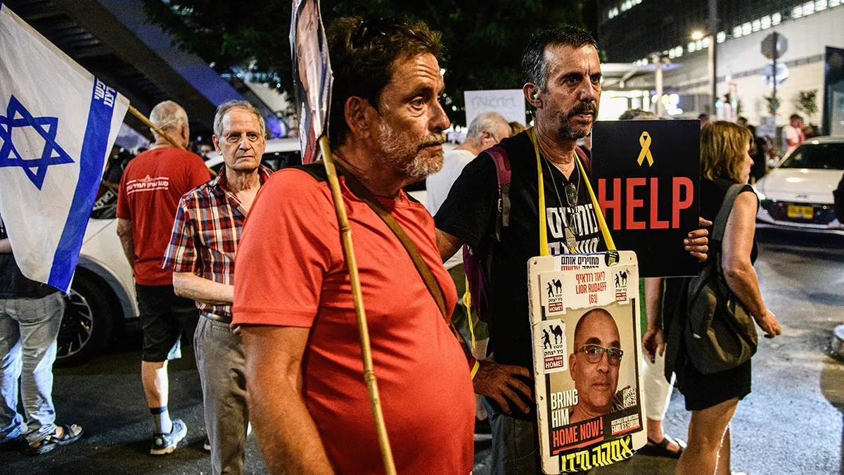 Prosvjednici stoje sa znakom izraelskog taoca Liora Rudaeffa 