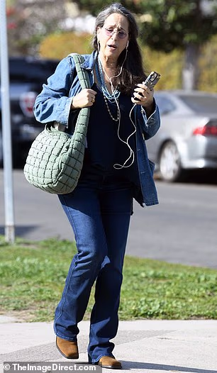 Pramenovi su joj prirodno padali niz ramena, au ruci je držala i svoj pametni telefon