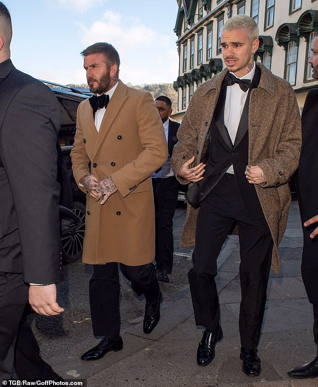 Sir David izgledao je elegantno u smeđem kaputu s dvorednim kopčanjem prebačenim preko crno-bijelog smokinga kad je stigao zajedno sa sinom Romeom, 23