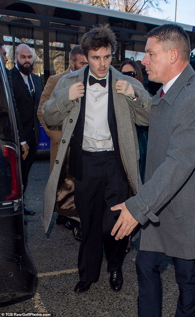 U međuvremenu, Cruz, 20, stigao je u sivom kaputu od tvida prebačenom preko smokinga, izlazeći sa svojom obitelji