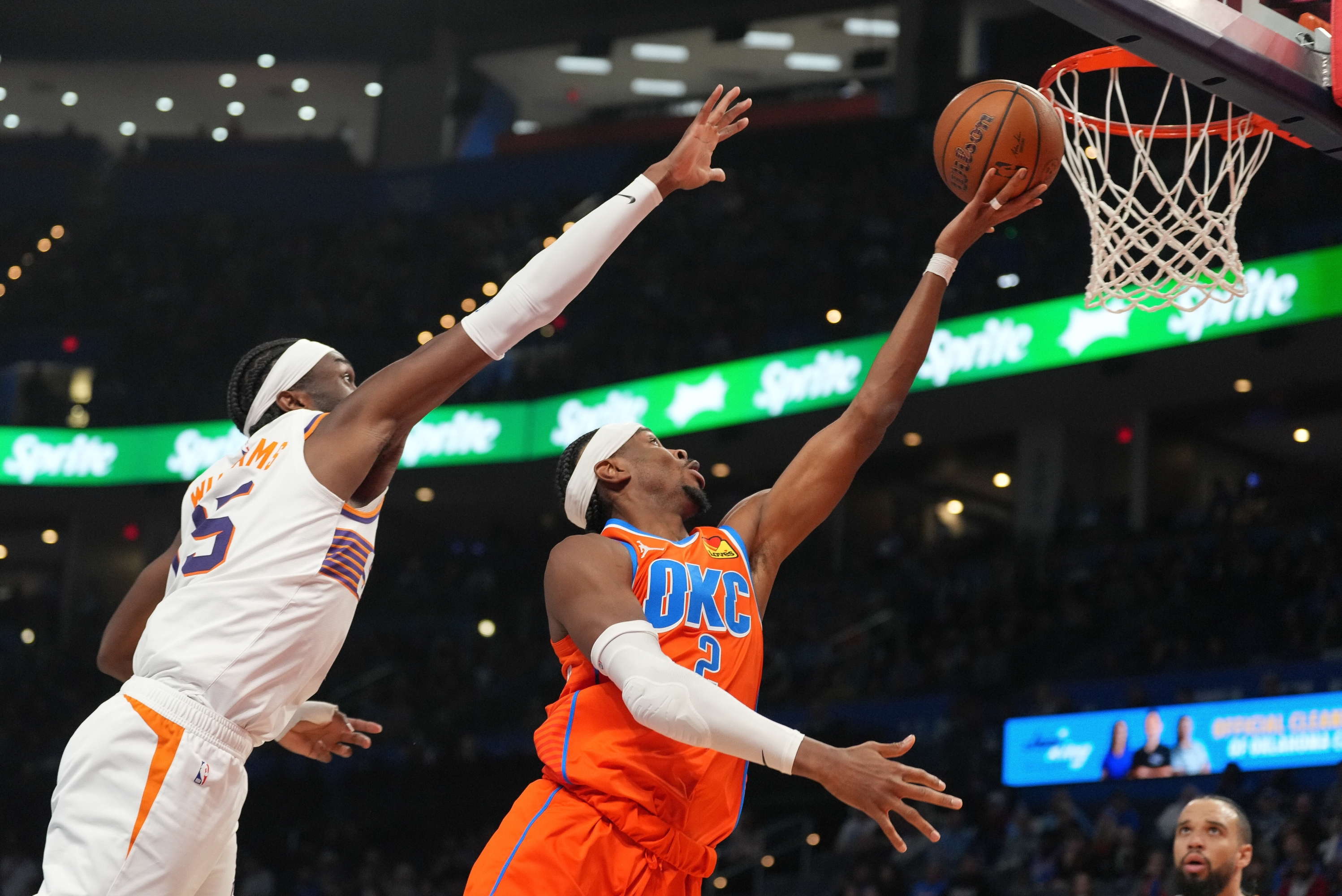 Stražar Oklahoma City Thundera, Shai Gilgeous-Alexander, desno, puca ispred centra Phoenix Sunsa, Marka Williamsa, lijevo, tijekom drugog poluvremena košarkaške utakmice NBA kupa, srijeda, 10. prosinca 2025., u Oklahoma Cityju. (AP Photo/Kyle Phillips)