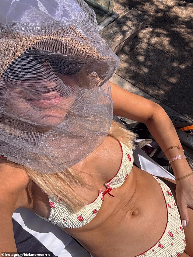 Pogodi tko? Australska TV zvijezda se inkognito razmeće svojim LUDIM tijelom u oskudnom bikiniju i mrežici za glavu tijekom ‘najgore sezone muha u 40 godina’