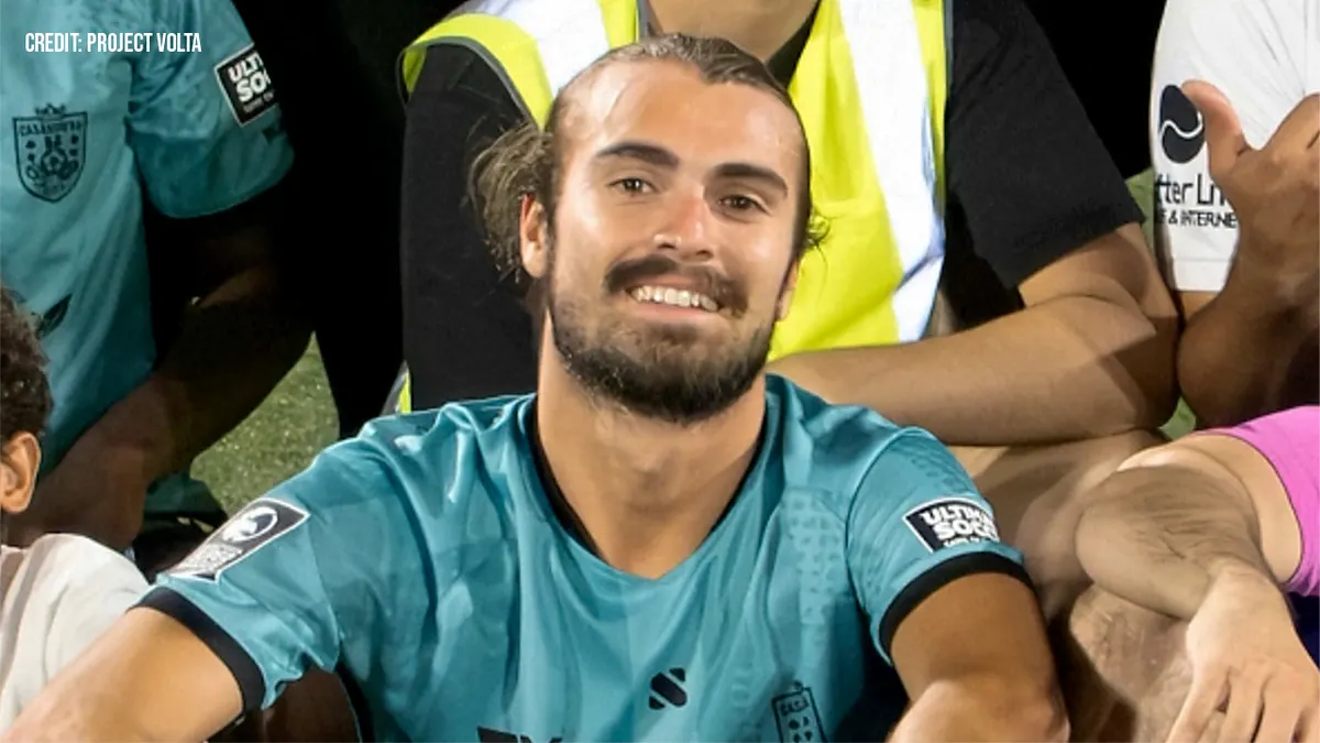 Nogomet igra sjedeći na travi za grupnu fotografiju.