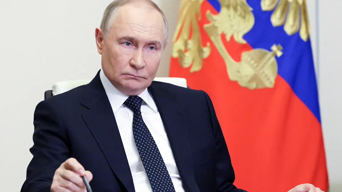 Ruski predsjednik Vladimir Putin drži olovku za stolom