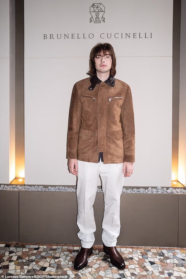 Gene je skrojio modernu figuru u smeđoj jakni od brušene kože i uskladio sa svojim bratom s istim bijelim hlačama