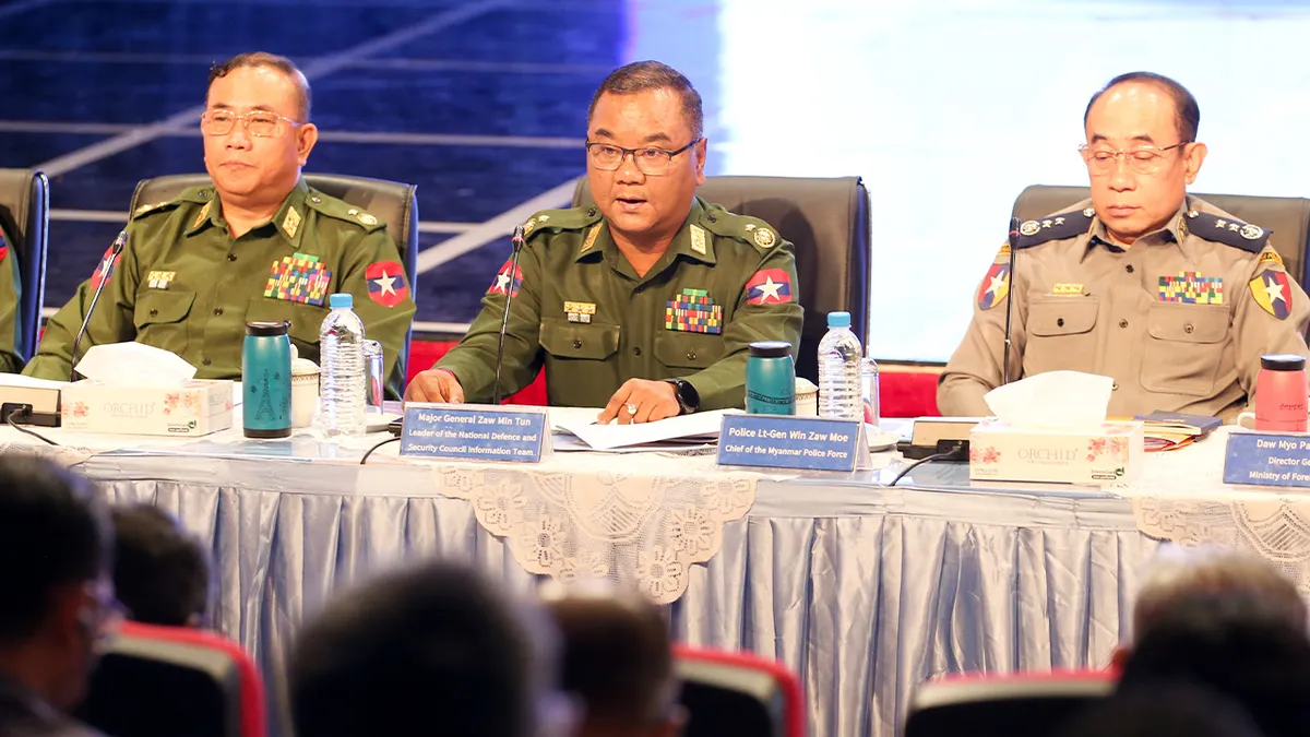 Vladin dužnosnik govori za govornicom tijekom brifinga, s mikrofonima i pozadinom iza sebe.