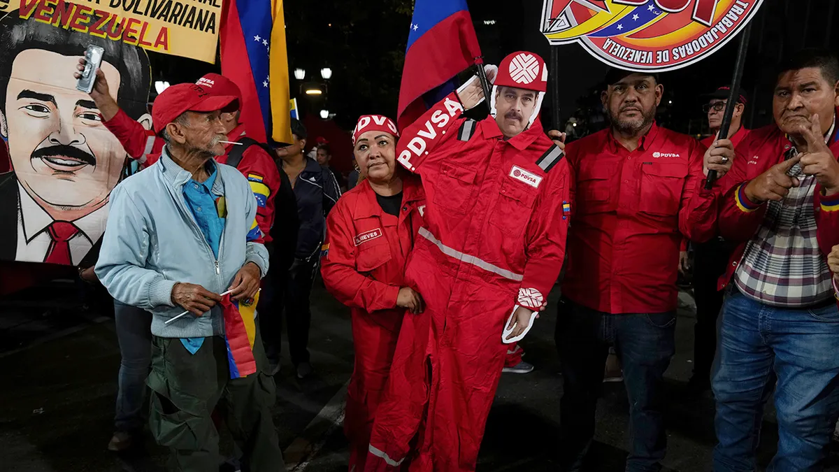 Naftni radnik drži isječak Madura odjeven kao zaposlenik PDVSA-e