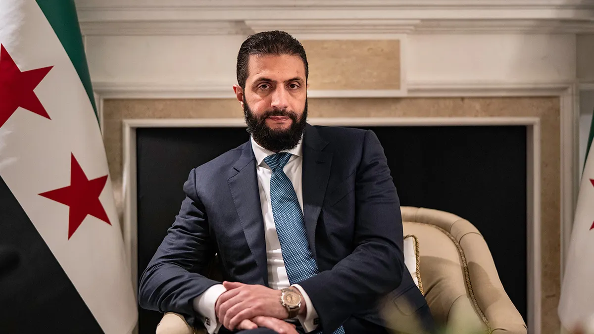 Sirijski vođa Ahmed al-Sharaa sjedi u stolici prekriženih ruku.