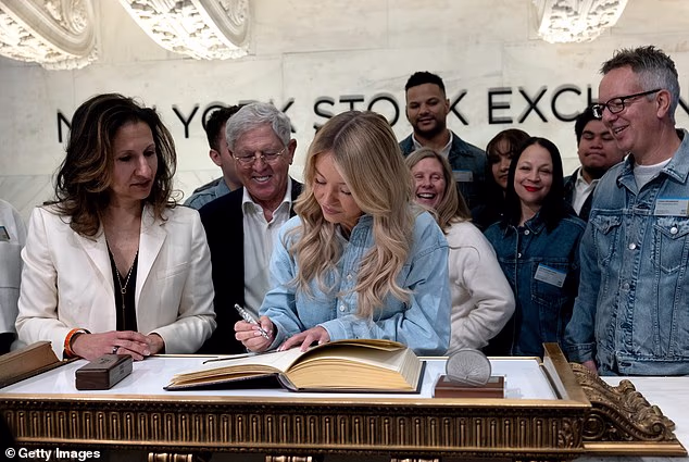 Rukovoditelji AE-a blistali su dok su gledali kako Sweeney potpisuje knjigu