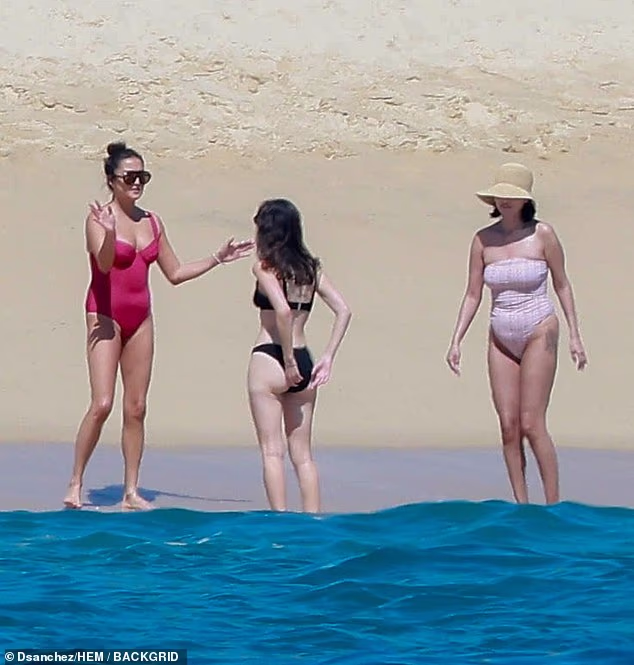 Gomezu su se na pljuskajućoj obali pridružili prijateljica koja je nosila jednodijelni kombinezon boje brusnice i prijateljica koja je nosila crni bikini