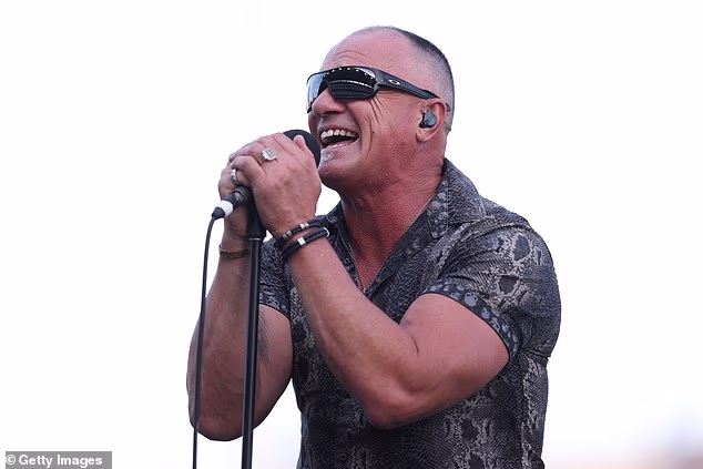 Nosio je privlačnu košulju s kragnom kratkih rukava koja je imala sivo-crni uzorak zmijske kože i motive lubanje koji su se protezali duž pojasa