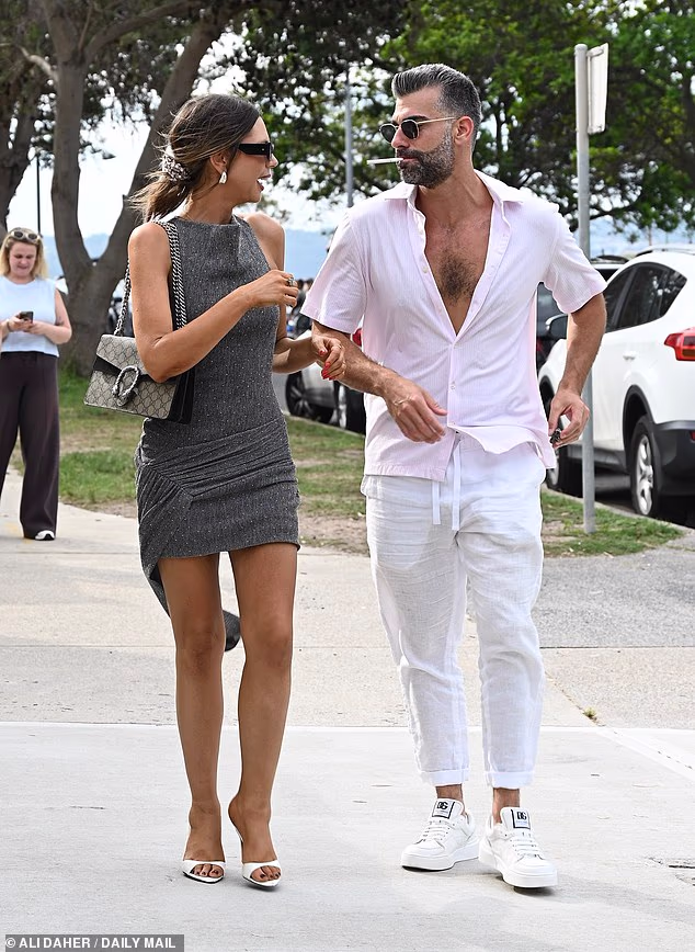 U međuvremenu, Joel je izgledao vrlo dotjerano u paru bijelih hlača i dječje ružičaste košulje, ostavljajući gornje gumbe otkopčane kako bi se vijorila njegova mišićava prsa