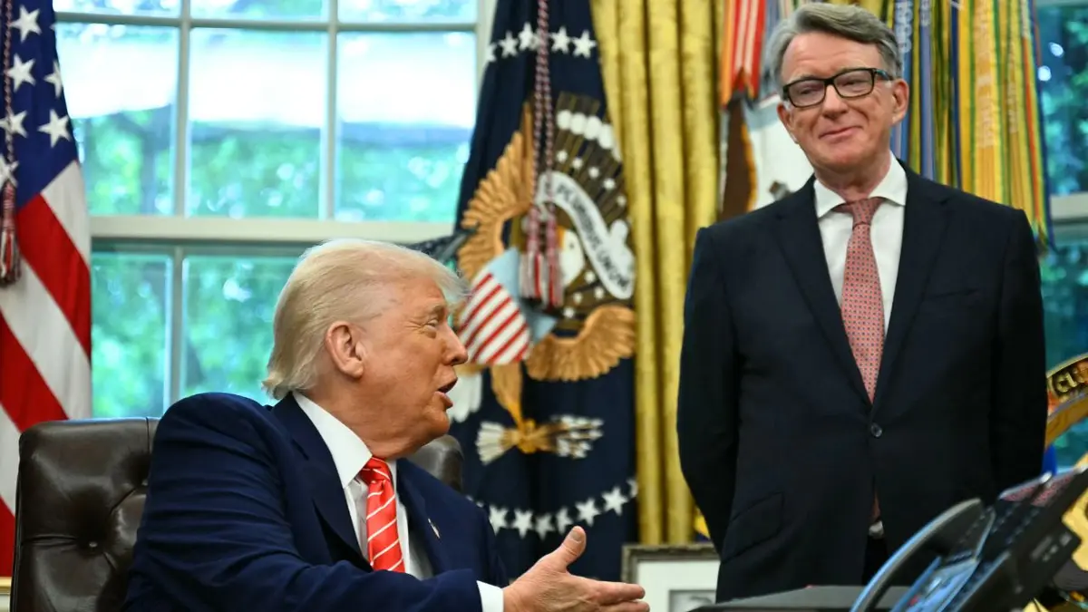 Donald Trump govori za Resolute Deskom dok Peter Mandelson stoji pokraj njega u Ovalnom uredu