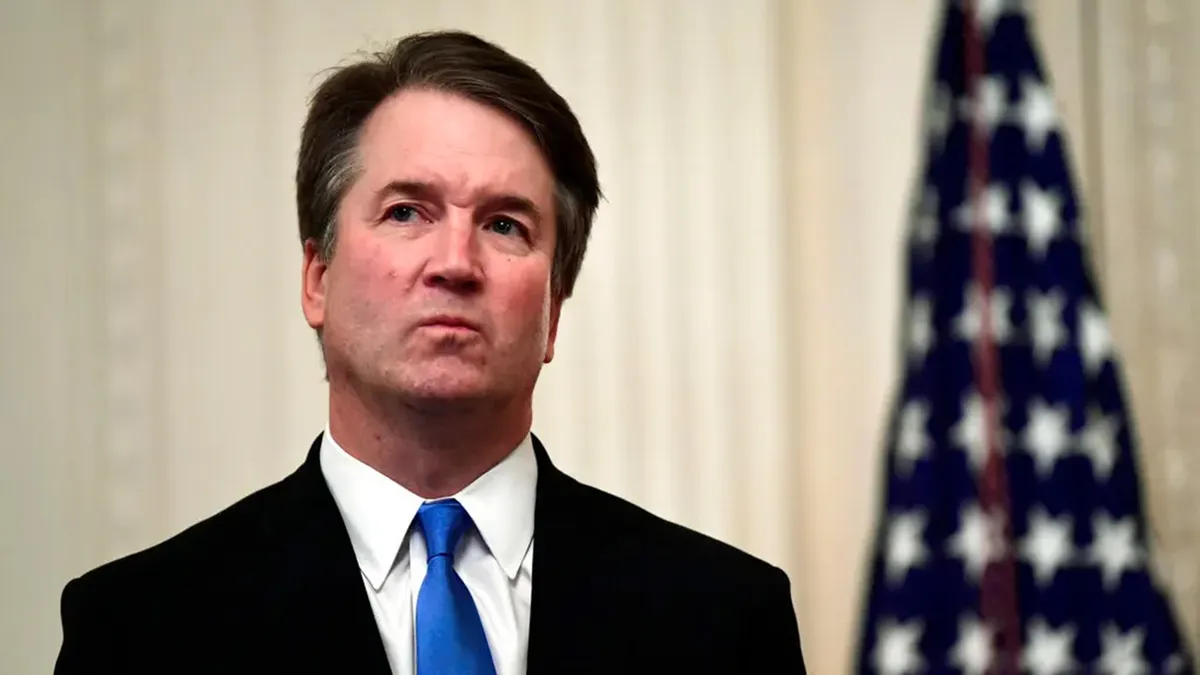 Brett Kavanaugh stoji u tamnom odijelu s plavom kravatom