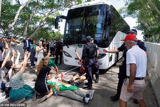 Nekoliko prosvjednika je prikazano kako leže i kleče na zemlji u pokušaju da blokiraju vozilo koje je prevozilo tim u zračnu luku Coolangatta