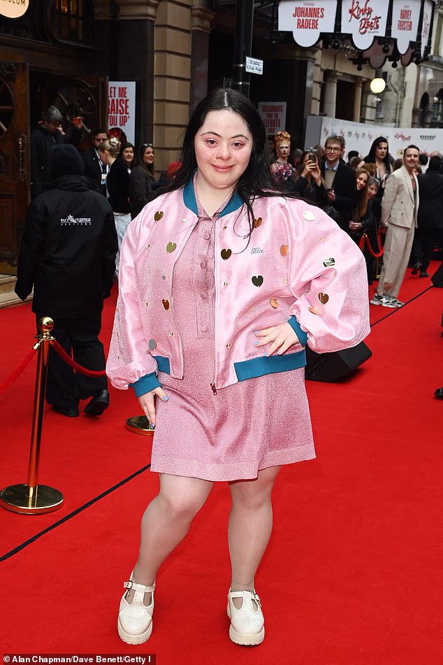 Ellie Goldstein pozirala je u svojoj tamnoružičastoj mini haljini i odgovarajućoj personaliziranoj jakni te bijelim cipelama s platformom