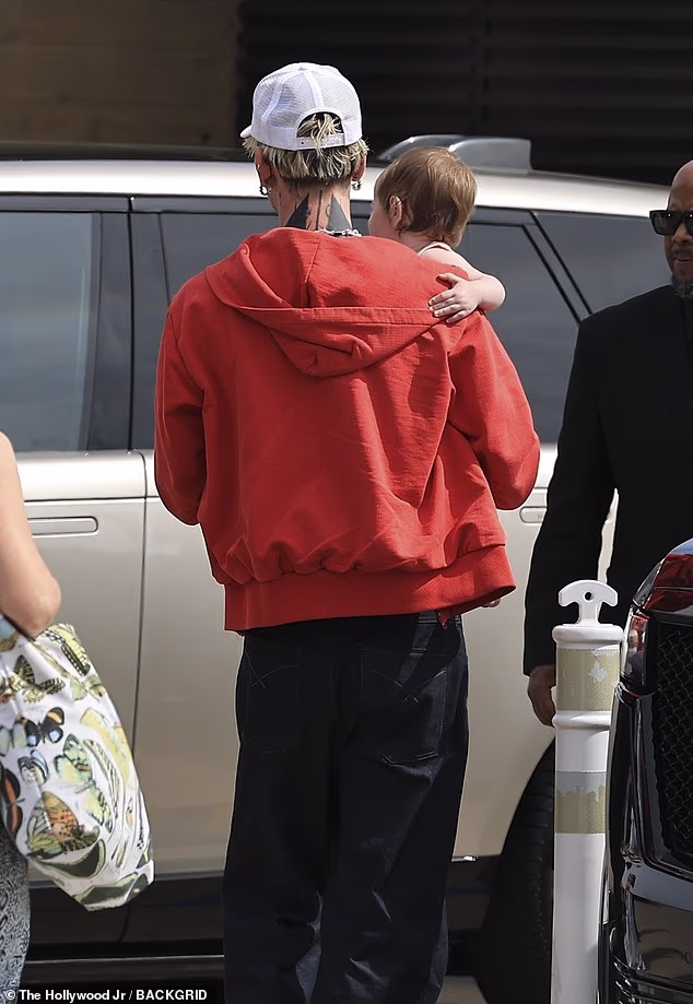 Nosio je indigo plave traperice s bijelom majicom bez rukava, crvenu majicu s patentnim zatvaračem i bijelu Lost Americana šešir iz svoje robne linije