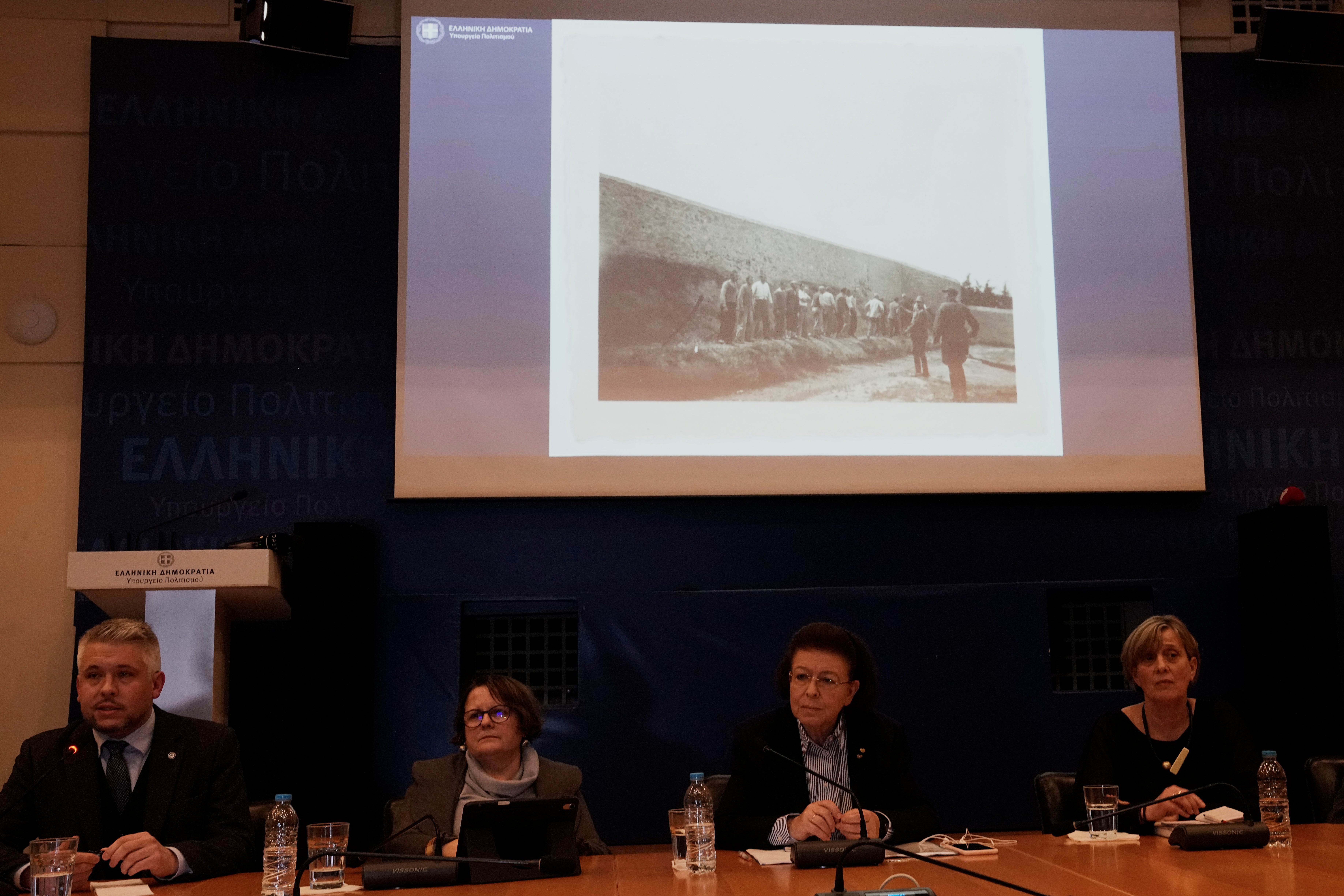 Fotografije koje prikazuju posljednje trenutke grčkih zarobljenika prije nego što su ih nacističke snage pogubile na poligonu Kaisariani u Ateni 1. svibnja 1944., predstavila je grčka ministrica kulture Lina Mendoni, druga desno, nakon što je država preuzela ratnu arhivu, u Ateni u četvrtak, 5. ožujka 2026. (AP Photo/Thanassis Stavrakis)