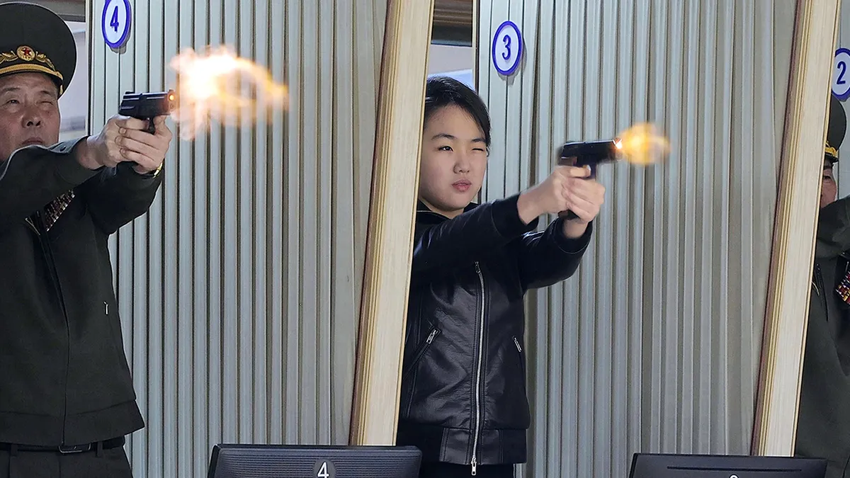 Kći Kim Jong Una, sredina, isprobava novi pištolj u tvornici za proizvodnju pištolja