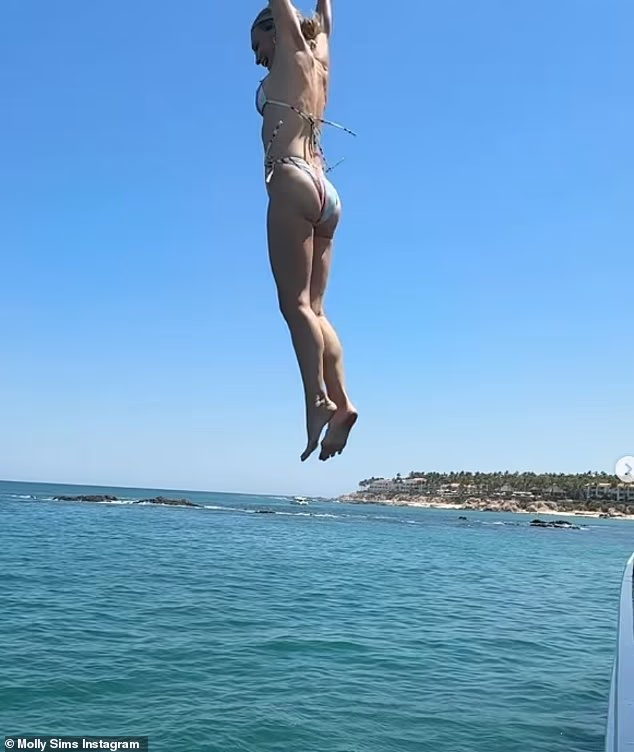 Glumica je podigla ruke dok se smiješila gledajući dolje u vodu