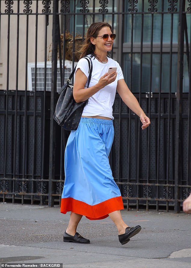 Ležerno, ali šik odjevena u jednostavnu bijelu majicu kratkih rukava koja je bezobrazno gledala na njezinu zategnutu tjemenu, Holmes je blistala