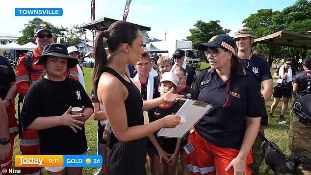 Bilo je teško promašiti njezine obloge dok je donosila novosti o vremenskoj prognozi s humanitarne trke u Townsvilleu, držeći međuspremnik u zavijenoj ruci unatoč ozljedi