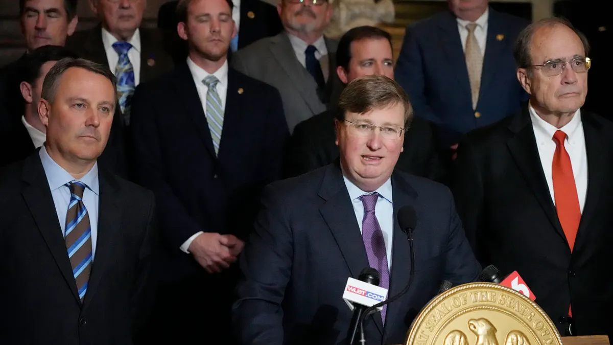 Guverner Mississippija Tate Reeves govori na Capitolu Mississippija u Jacksonu s potguvernerom Delbertom Hosemannom i Jasonom Whiteom